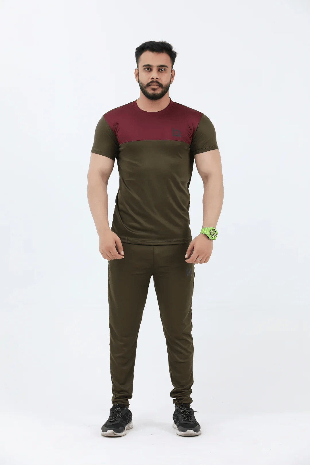 Man wearing a green and maroon athletic outfit on a white background